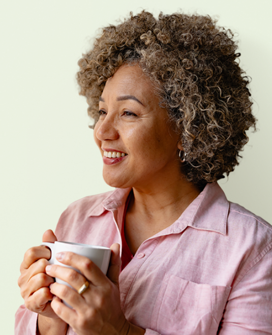 A woman smiling, holding a mug.