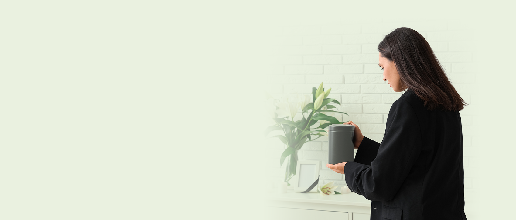 A women holding an ashes urn at a memorial service.