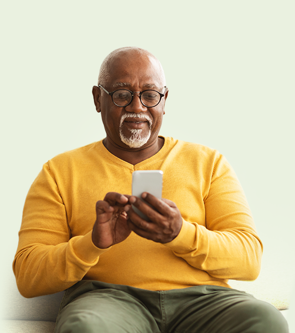 Man in yellow jumper searching for Fond Farewell Cremations on his mobile phone.