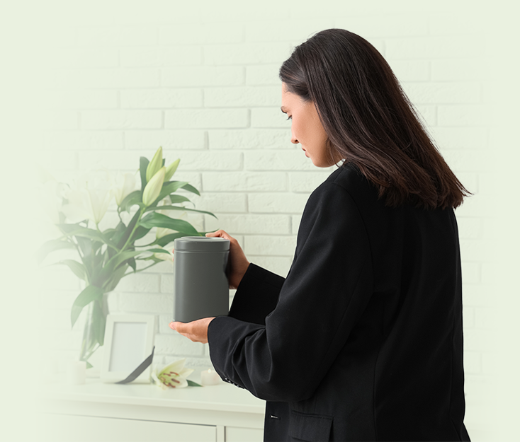 A women holding an ashes urn at a memorial service.